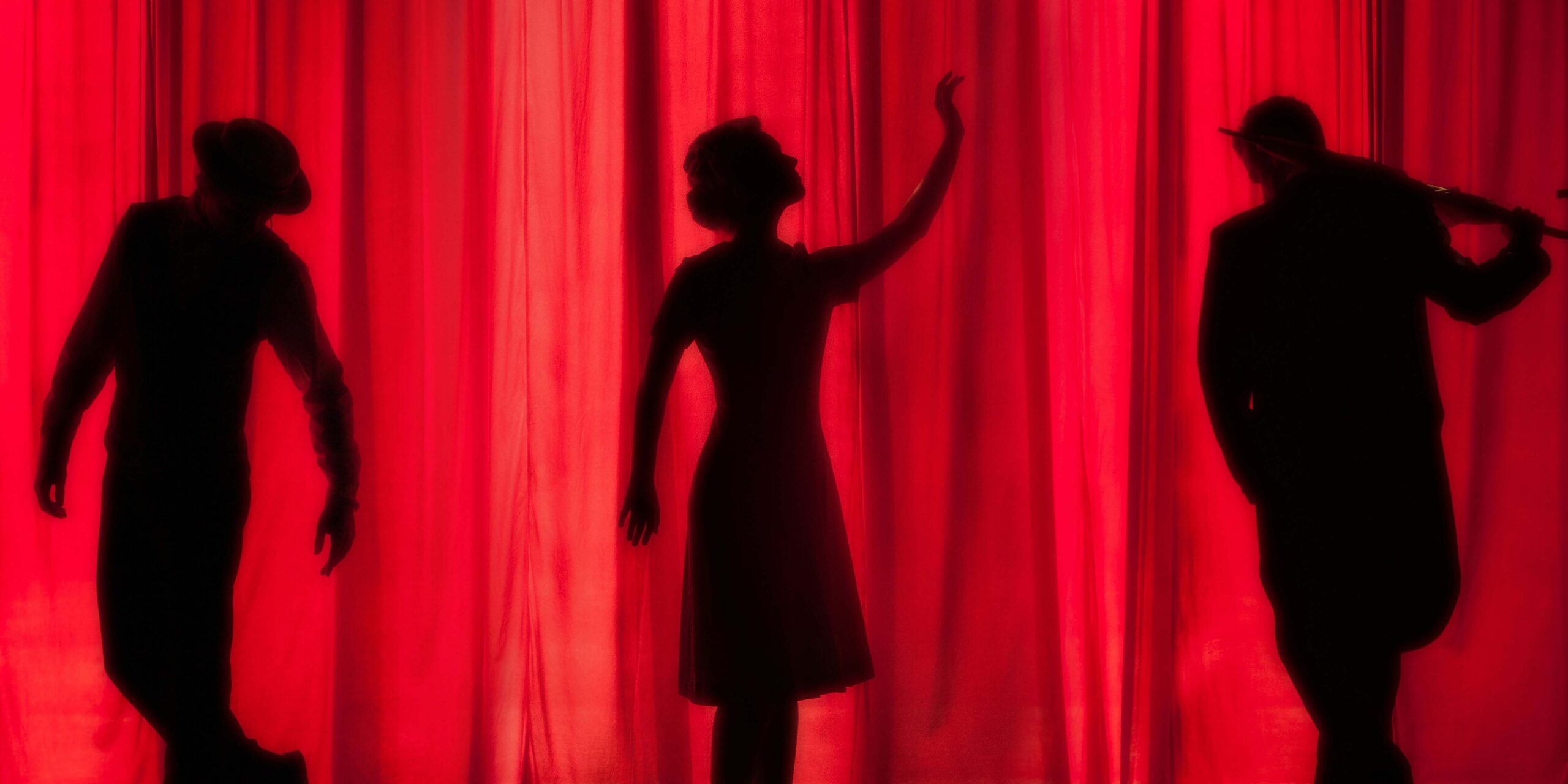 comédien de pièce de théâtre derrière un grand rideau rouge